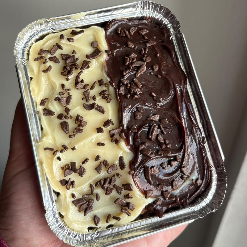 Brownie com cobertura de chocolate branco de um lado e de chocolate do outro, com granulado de chocolate